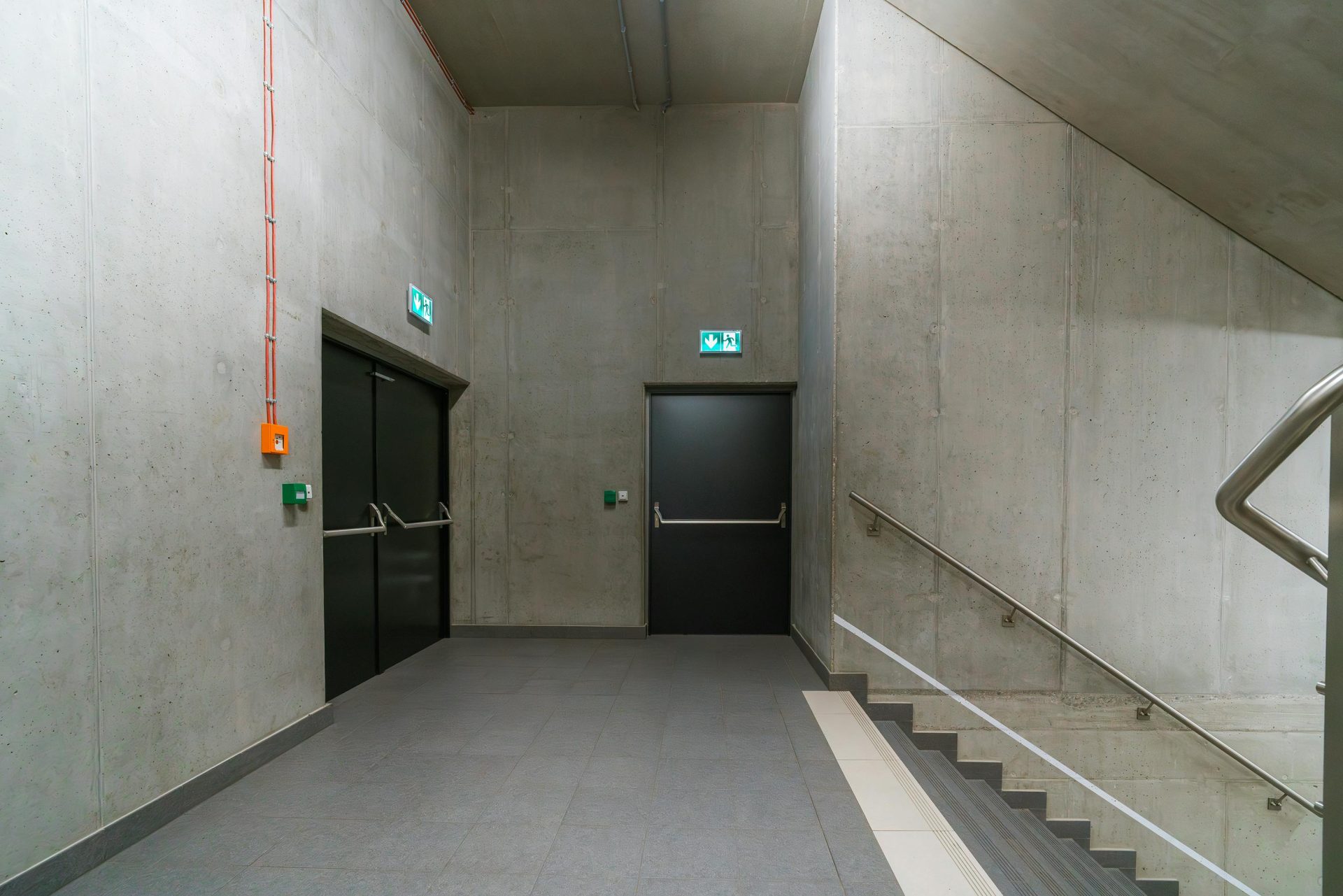 Moderne Innentreppe mit Notausgangstüren in einem Industriegebäude.